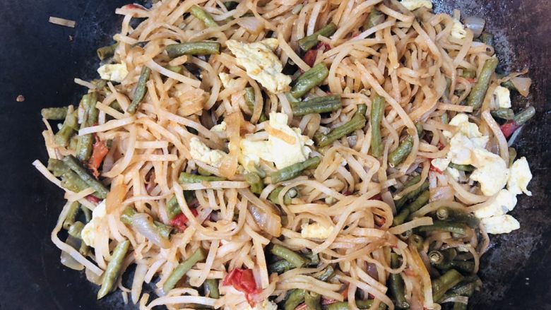 豆角鸡蛋炒饼,焖透饼丝后,把饼丝和菜搅拌均匀。