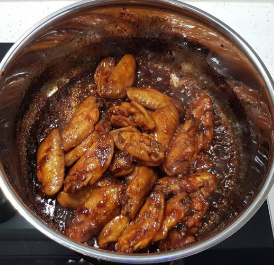 蒜香蜂蜜啤酒鸡翅,打开锅盖,将鸡翅拌炒翻面,继续煮至酱汁收乾,即可关火盛盘。