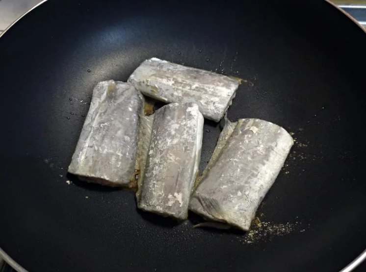 香柠乾煎白带鱼,先热锅完成再倒点油, 依序放下沾好煎鱼粉的白带鱼,切记不要马上急著翻面。