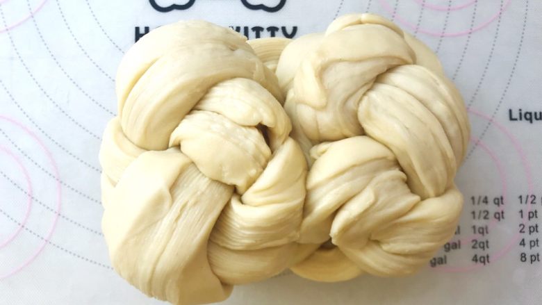 手撕金砖吐司,将编好的辫子翻个面,将两侧向中间对折,对折处捏在一起