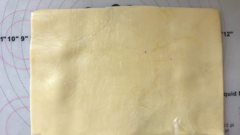 手撕金砖吐司,黄油软化后,用手先将裱花袋的两个角捏满,之后对折裱花袋,将黄油擀成厚度均匀的黄油片,同样放冰箱冷冻7、8分钟
