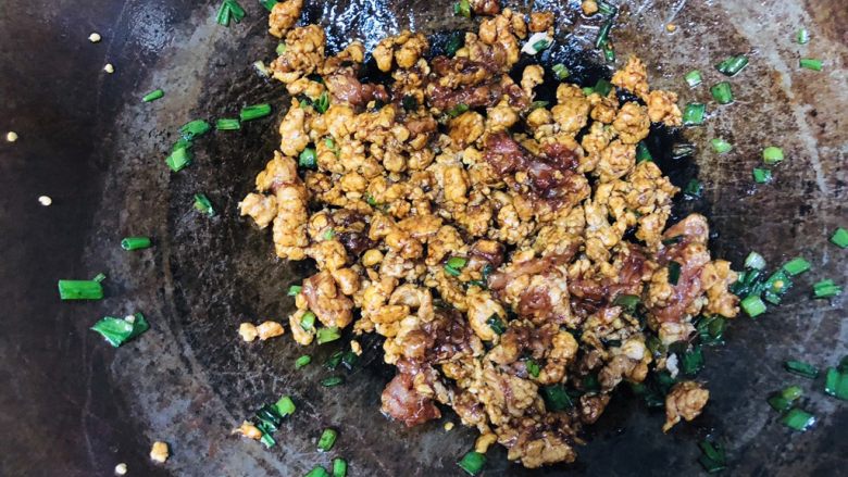 经典肉末茄子,锅中再放油,油热倒入小葱和肉末,再加适量食盐和酱油,翻炒。