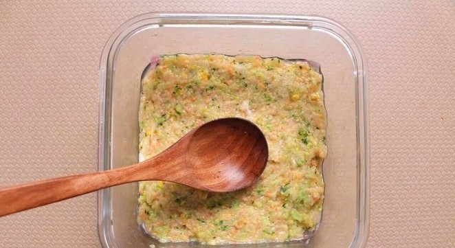 西兰花玉米鸡肉糕,倒入鸡肉泥蔬菜泥,用勺子压实抹平
