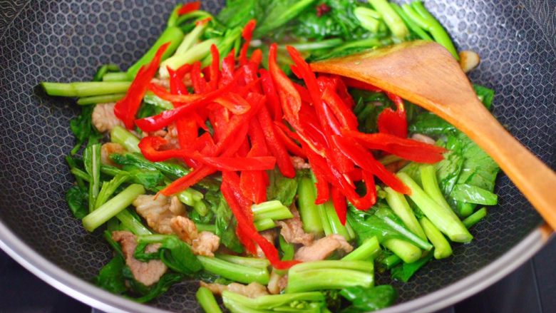 菜心红椒炒肉片,看见菜心断生变软的时候,加入红椒丝。