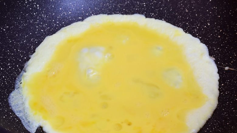 青椒火腿肠炒鸡蛋,锅中倒入适量的食用油烧热,倒入鸡蛋液