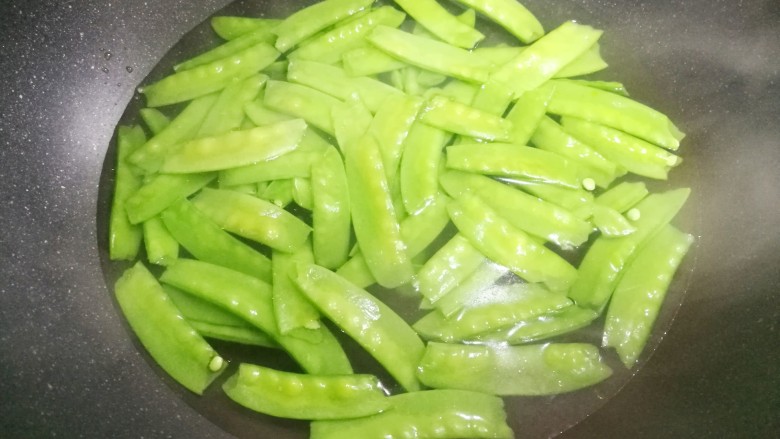 荷兰豆炒腊肠,锅中烧开水,加少量油和盐,放入荷兰豆焯水1分钟。