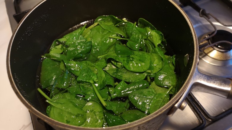 虾丸菠菜汤,水开之后,把菠菜放入水中。
