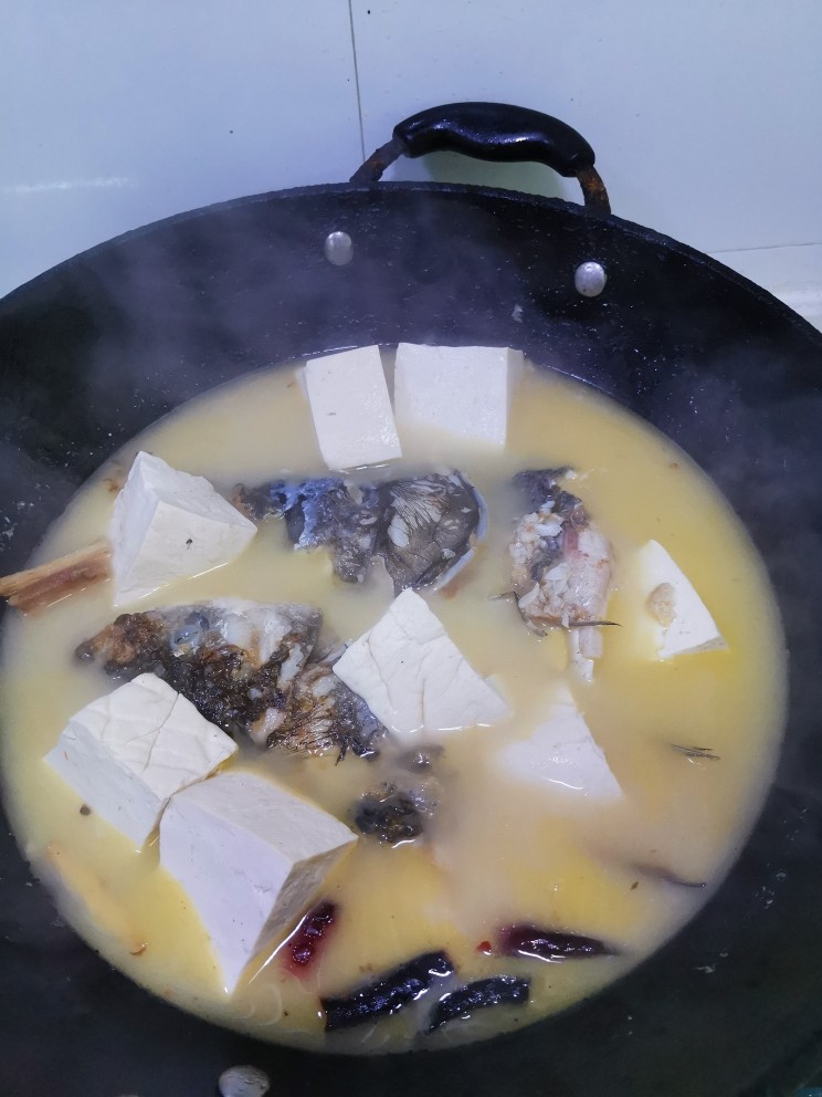 鱼头豆腐汤,大火煮开后转小火,继续炖二十分钟。喜欢的话撒点小葱或者香菜出锅。最后加盐调味,味精的话没这个习惯,经常忘