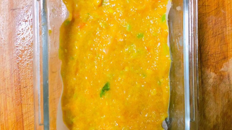 西兰花玉米鸡肉糕,倒入搅拌好的西兰花玉米鸡肉泥并铺平