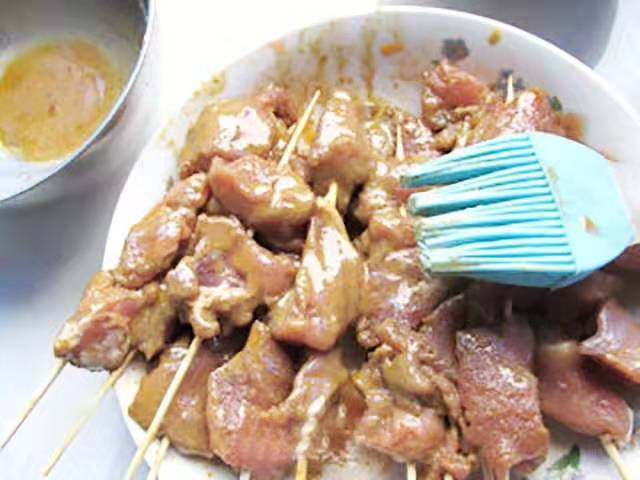 孜然羊肉串,把调好的料汁刷在肉串表面