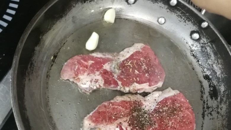 迷迭香黑胡椒牛排,放入几头蒜粒,给油加点蒜香味,有带皮蒜更好了,最后可以吃点