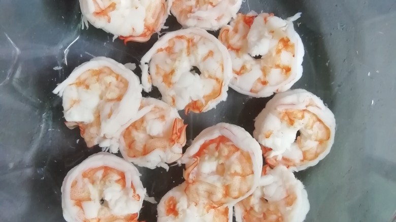 西红柿百香果凉拌虾,解冻好的南美白虾开背去壳去虾线,清洗干净,锅中放水烧开,放2片生姜和虾煮熟,捞出放冰水中。