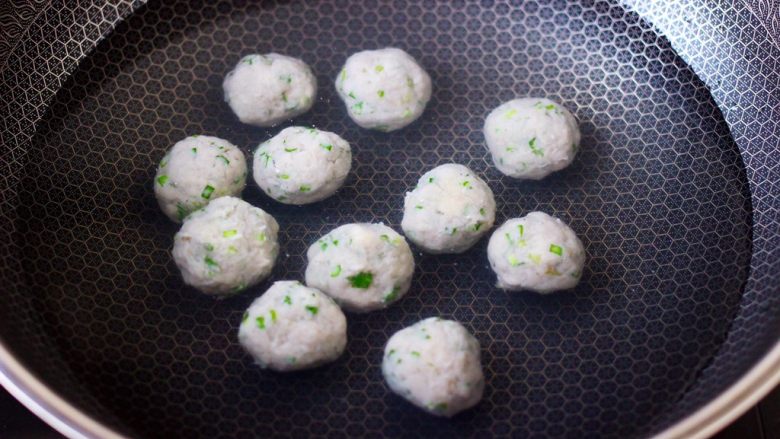 手工九道箍鱼丸,锅中倒入适量的清水,把搅拌好的鱼馅,团成丸子放入锅中。