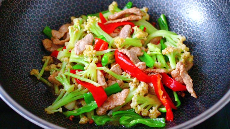 双椒肉片炒花菜,大火翻炒至青红辣椒,断生变色即可关火。