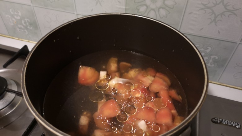 番茄肉圆汤,锅内烧开水,下入番茄丁。