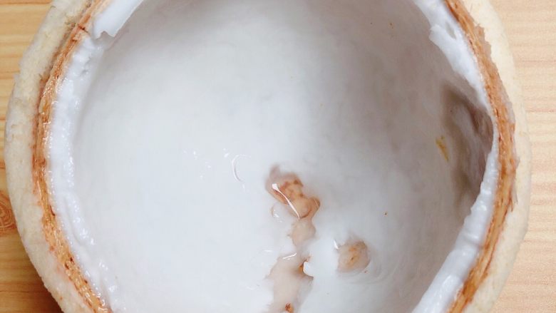 鲜椰浆苦咖啡绵绵冰(椰子油奶白顺滑诱人极了),首先将椰子从2/5的位置砍开。