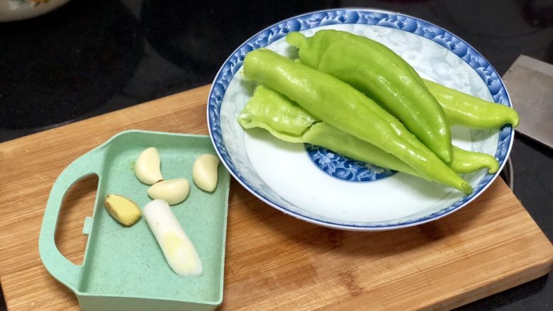 嫩绿纷红不自愁➕尖椒木耳回锅肉,准备好五花肉，再来处理蔬菜。蒜剥皮姜去皮与葱白洗净。尖椒去蒂去籽洗净，怕辣的记得把尖椒的筋撕去