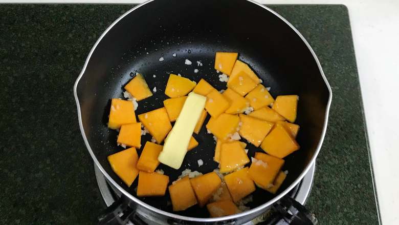 南瓜香肠芦笋意面,开火,锅中倒入食用油,加入蒜蓉爆香,接着加南瓜翻炒,加<a style='color:red;display:inline-block;' href='/shicai/ 887'>黄油</a>。