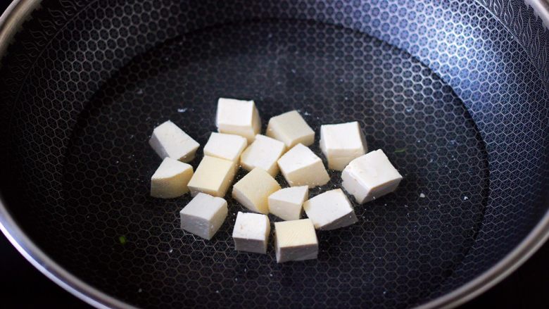 丝瓜花蛤炖豆腐,锅中倒入适量的清水,加入少许盐,把豆腐进行焯水,焯一分钟左右即可捞出沥干水分。