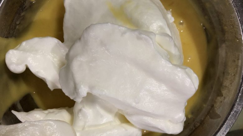 十寸戚风蛋糕(不开裂),在蛋白霜里加入三分之一蛋白霜,用硅胶刀翻拌均匀,用J或Z字型翻拌均匀,不要画圈搅拌以免蛋白消泡。