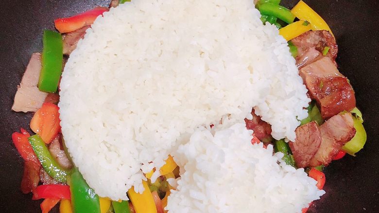 彩椒肘花肉炒饭(5分钟快手炒饭),放入米饭,改为中小火,用铲子将米饭分隔开,追减打散米粒,翻炒均匀。