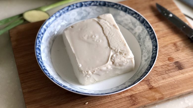 日影红霞里梦思➕腊肉豆腐肉饼蒸蛋,内脂豆腐的盒子四角剪小口,撕开包装,倒扣在盘子中