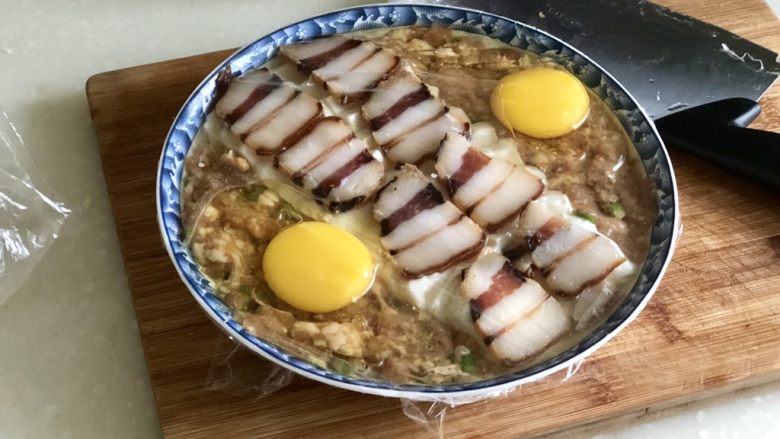 日影红霞里梦思➕腊肉豆腐肉饼蒸蛋,蒙上保鲜膜,表面用牙签戳几个洞
