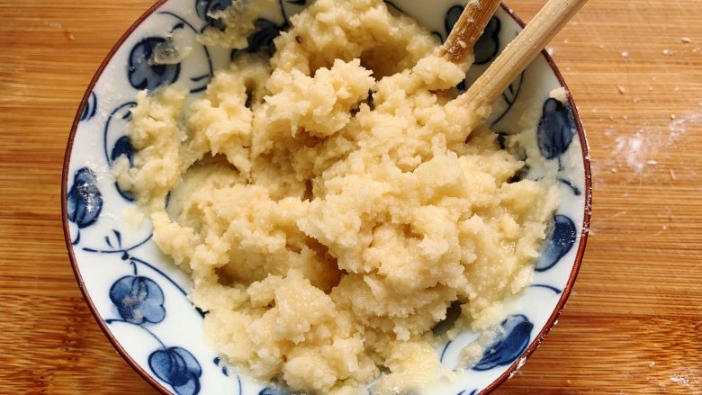 发面豆沙油酥饼,面团发酵的时候来制作油酥,把200克面粉放入碗里,倒入加热好的食用油,用筷子搅匀,即成油酥面团。