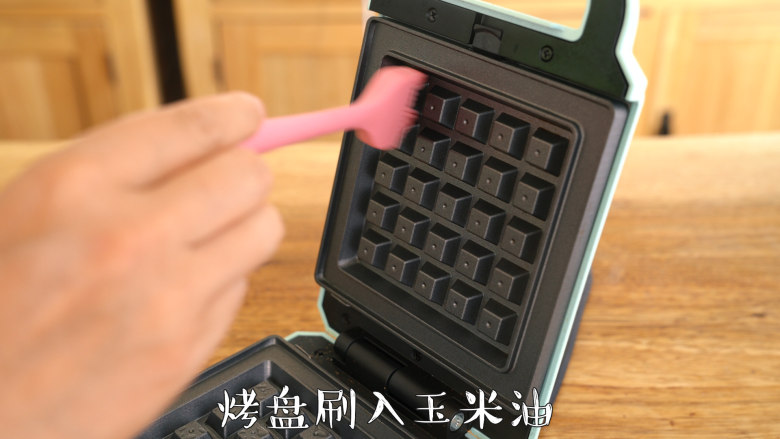 【布鲁塞尔松饼】浓浓巧克力风味,早餐机预热至红灯灭,烤盘刷上玉米油,使用挖球勺舀入约65g面糊,盖上上盖,烘烤6分钟,取出置于晾架晾凉