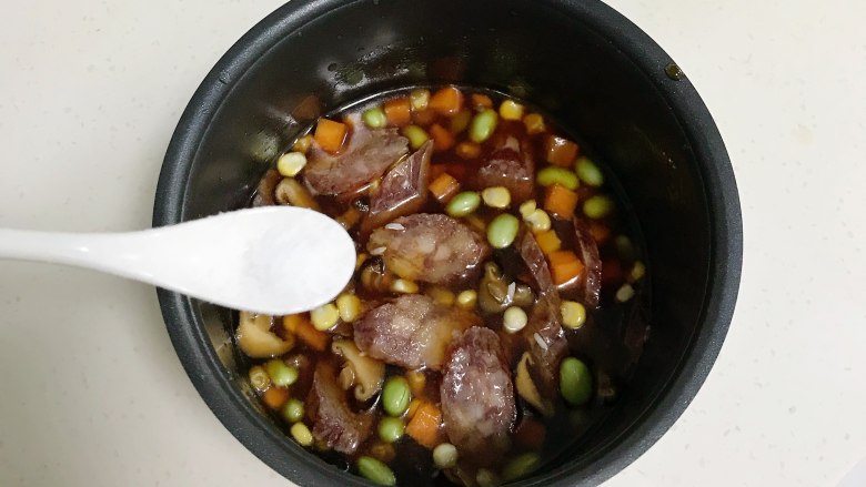 腊肠时蔬焖饭,加入少许盐,稍微搅拌下。