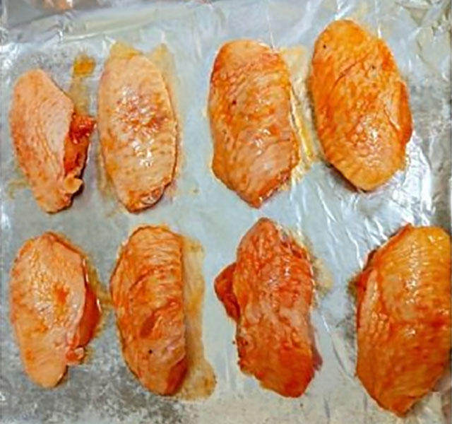烤箱版奥尔良烤鸡翅,取出,烤盘铺好锡纸,摆上鸡中翅。