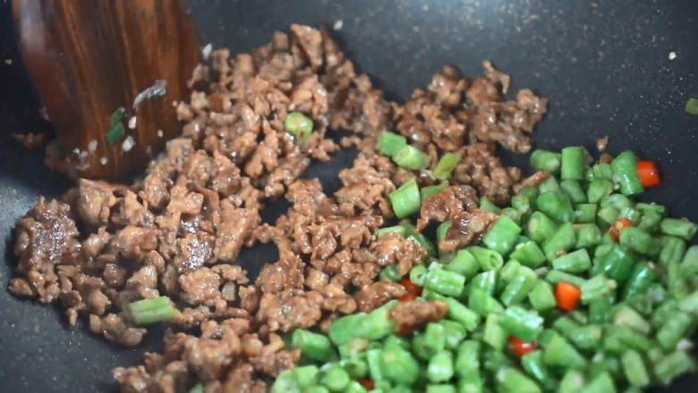 这道开胃下饭小菜,简单易学超快手,腌好的肉末炒至变色再与豆角炒匀。
