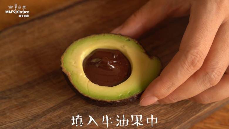 感受水果原香【牛油果冰淇淋】,取出果核;使用巧克力融锅将黑巧克力融化,填入果核凹槽里面,冷藏30分钟至巧克力凝固变硬。