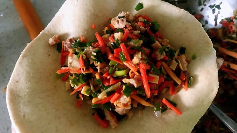 莜麦面馅饼,发好的面团放在案板上揉搓一下,切成大小一样的面剂子和包包子一样擀成小圆饼,里面放馅,馅大家可以自由的选择,我的里面放肉,胡萝卜,韭菜,还有一点豆腐干。