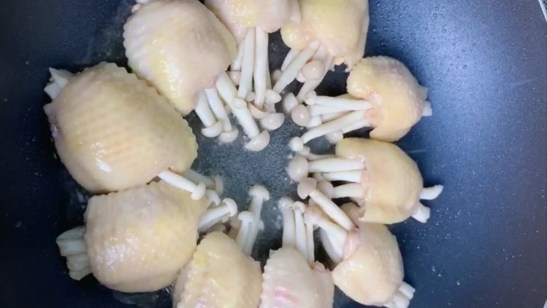 (家常菜)鸡翅包白玉菇,起锅烧油下入鸡翅小火慢煎
