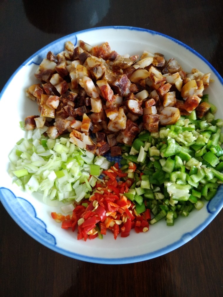香肠鸡蛋炒饭,把香肠,青椒,小米椒,葱切粒备用