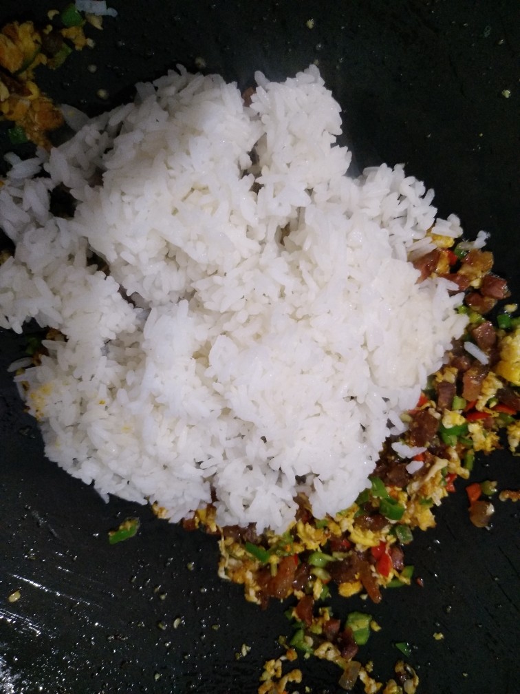 香肠鸡蛋炒饭,倒入米饭一起翻炒,把米饭炒散,看到米饭在锅里跳动