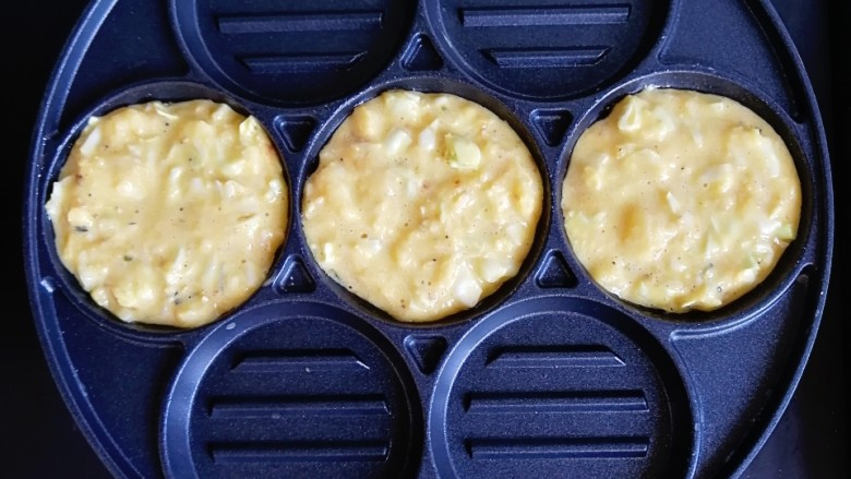 卷心菜鳕鱼虾皮蛋饼,取七孔锅刷一层油,一勺勺舀入饼糊