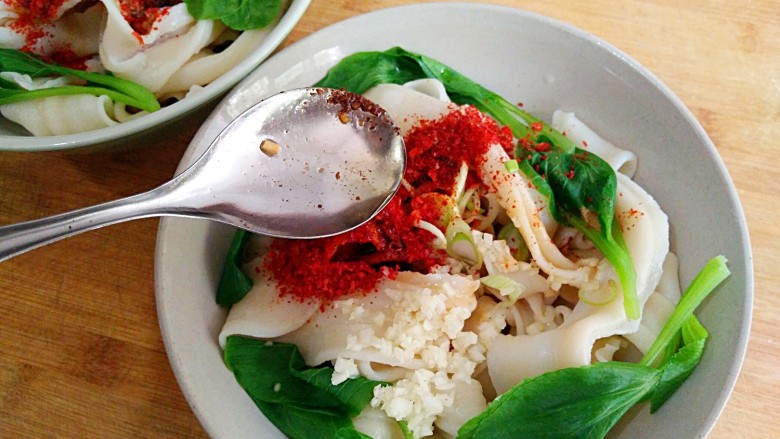 陕西油泼面,拿个勺子舀着热油泼把油浇到葱花蒜末辣椒粉和花椒粉上,这时辣椒粉和蒜末被热油一烫吱吱作响,香味立刻扑面而来。(建议不要直接泼 这样主要是控制不好油量,还有就是不均匀)