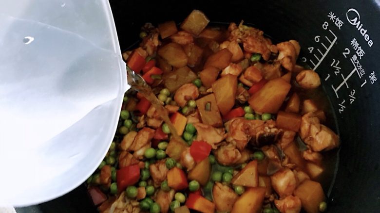 鸡腿焖米饭,倒入电饭锅的米饭上面,加入清水,清水的量和电饭锅中食材保持平面就可以。启动煮饭按钮键至机子自动停止工作。