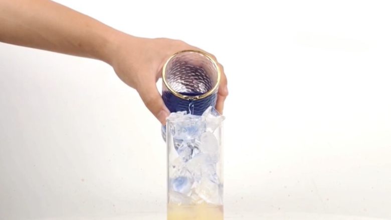 一杯梦幻海洋饮品，分层渐变柠檬蝶豆花茶,沿冰块倒入蝶豆花茶汤