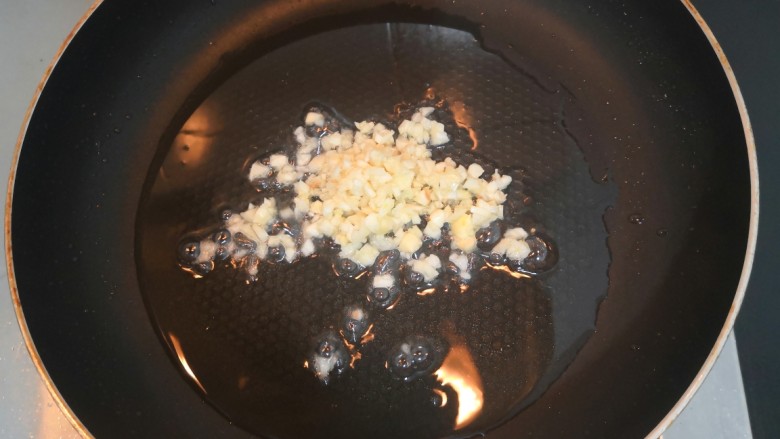 蒜蓉蒸丝瓜,热锅起油,倒入一半的蒜沫