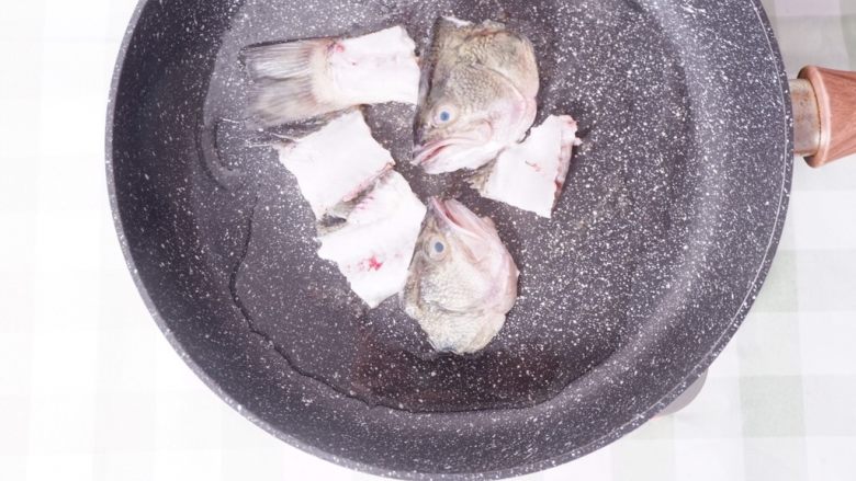 柠檬酸汤鲈鱼,热锅倒油,将鱼头鱼骨煎至焦黄
