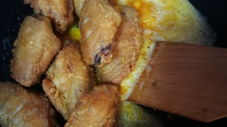 咸蛋黄鸡翅,鸡翅倒入锅中翻炒均匀,待蛋黄全部裹在鸡翅上,即可