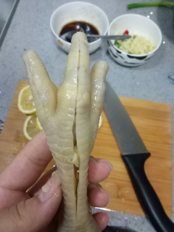 酸辣脱骨鸡爪,鸡爪捞出，鸡爪沿着骨缝来几刀，取出骨头。