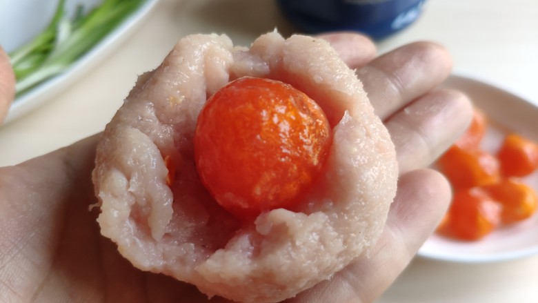 一颗有“内涵”的莲藕丸子,取适量肉馅中间按个坑,包上一颗鸭蛋黄,团成圆球状。