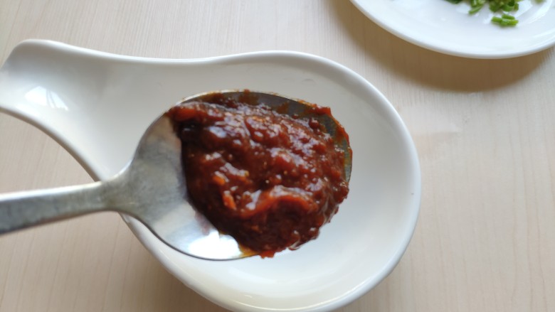 铁板豆腐,用一小碗调一个酱料。先加入一勺<a style='color:red;display:inline-block;' href='/shicai/ 814'>蒜蓉辣酱</a>,没有可换甜面酱或豆瓣酱。
