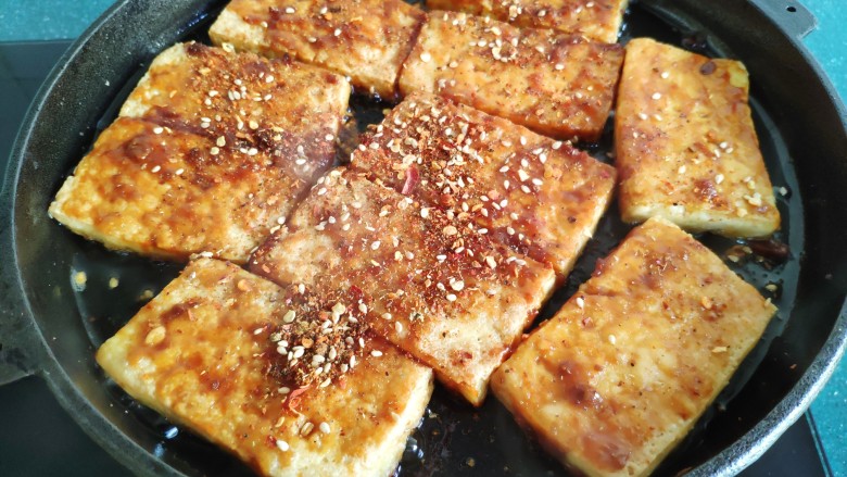 铁板豆腐,两面都刷上酱料后,撒上调好的芝麻辣椒粉。