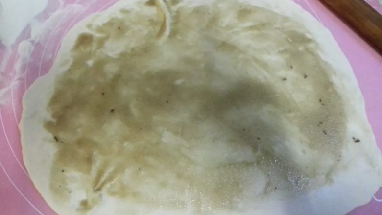 驴肉火烧,把面团从冰箱拿出,面团多可以切开分次擀面,把面团擀成椭圆形或圆形都可以,擀好后把酥油均匀的抹在面皮上。