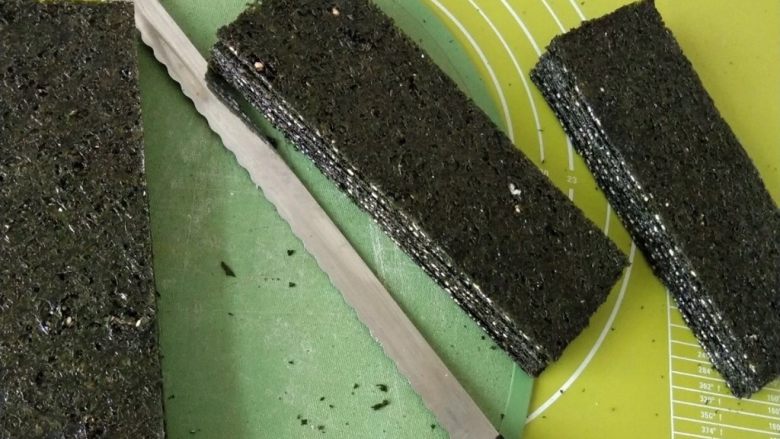 自制海苔片,从烤箱取出烤好的海苔片,用刀切成你喜欢的大小,我用面包刀切割的,做的也比较齐整。